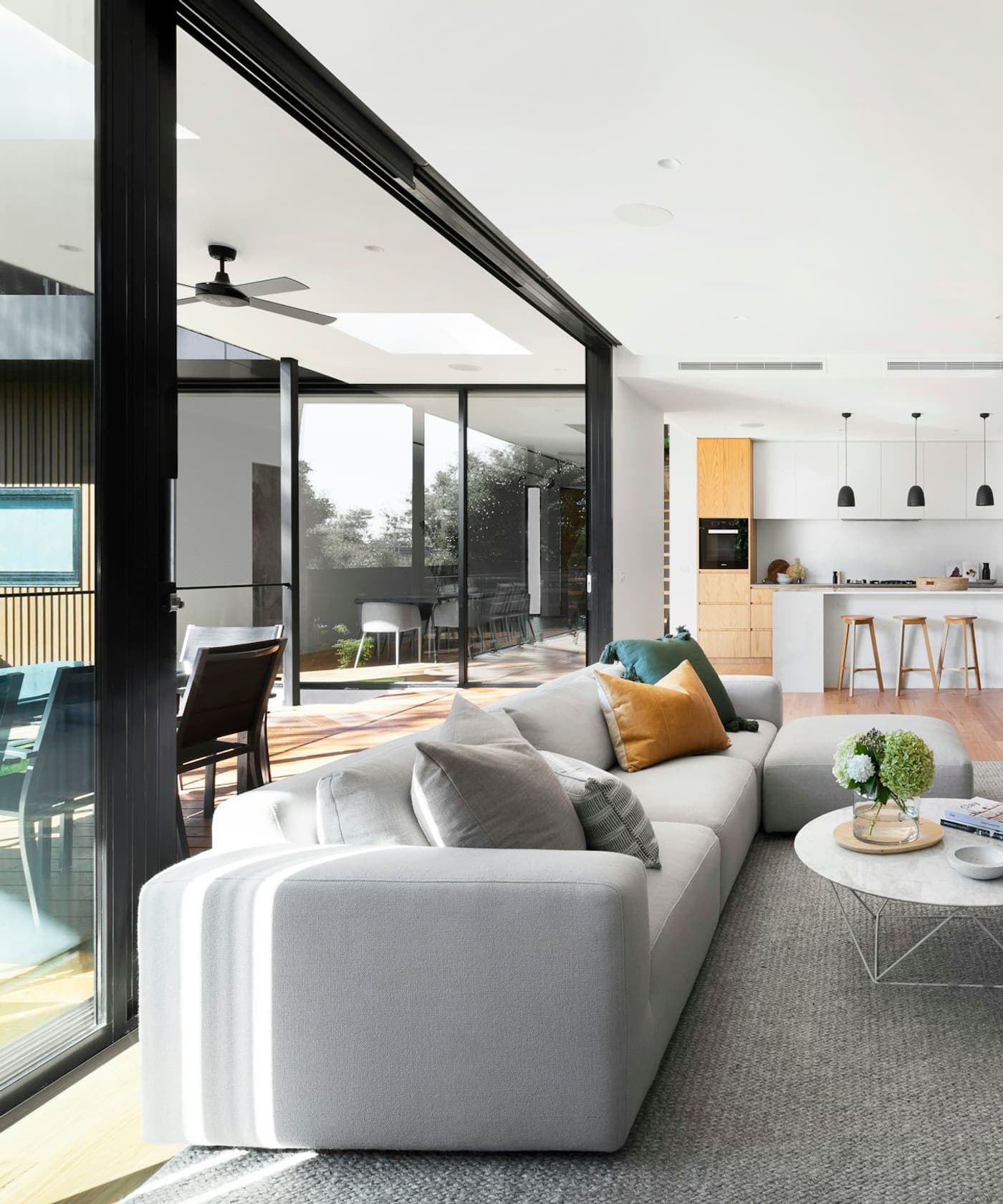 Open-plan living room with wood paneling and material study.