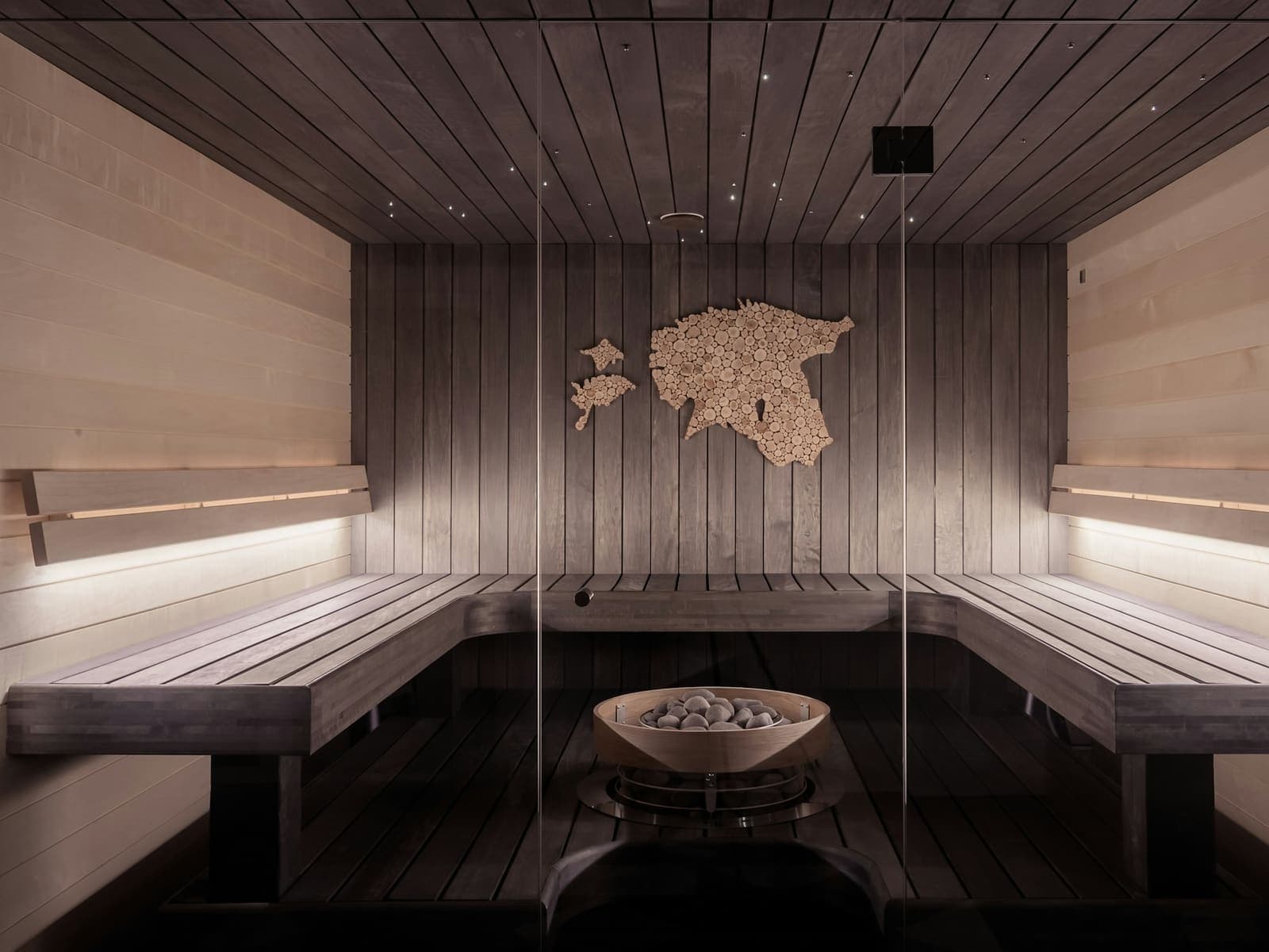 A luxury wood-clad sauna with cedar benches and ambient lighting.