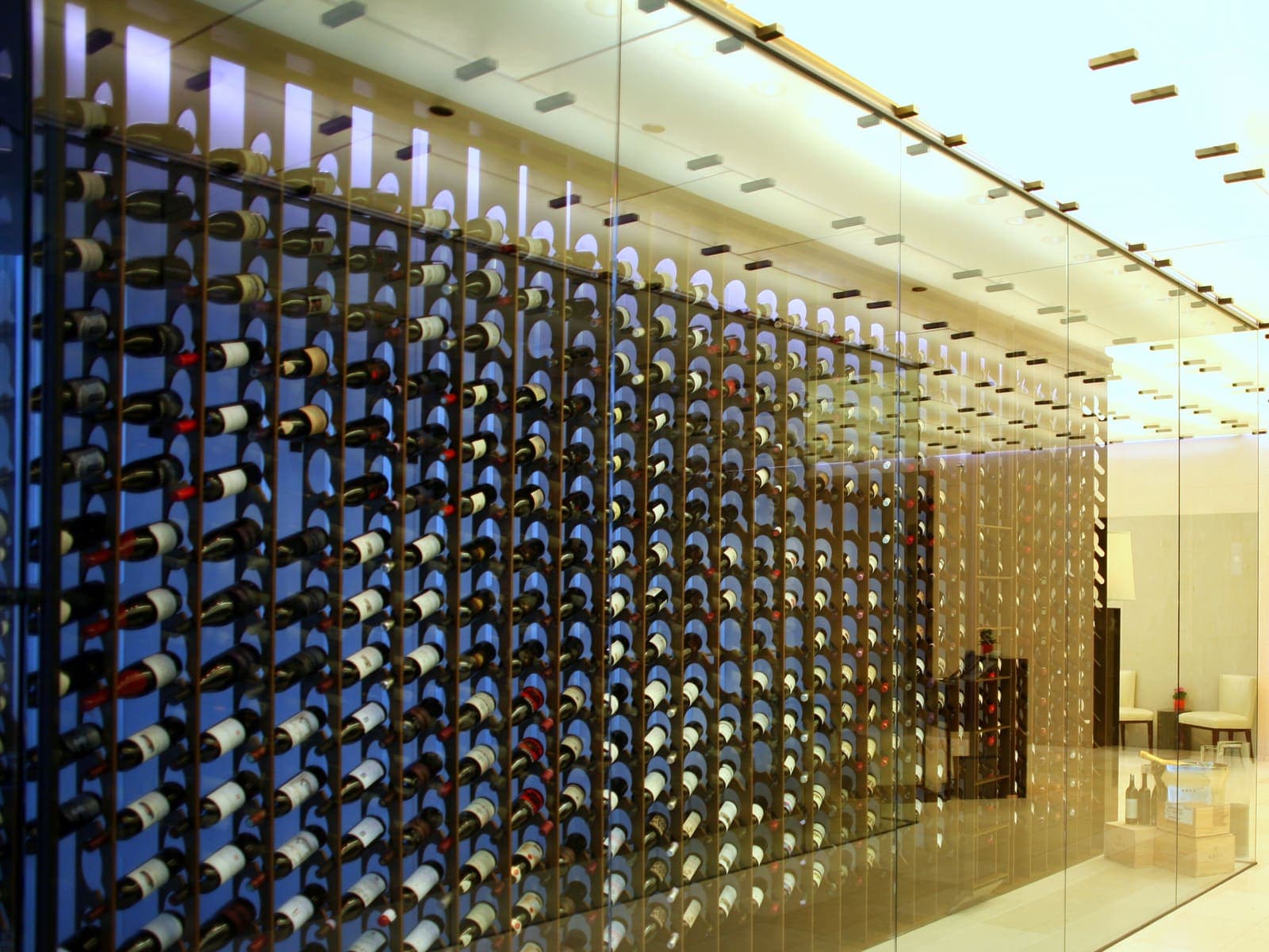 Brick-vaulted wine cellar with brass chandeliers and bottle racks.